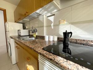 a kitchen with a sink and a counter top at Apartamentos Playa Oropesa 3000 in Oropesa del Mar
