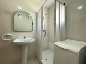 a white bathroom with a sink and a shower at Apartamentos Playa Oropesa 3000 in Oropesa del Mar
