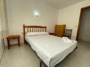 1 dormitorio con cama, mesa y espejo en Apartamentos Playa Oropesa 3000, en Oropesa del Mar