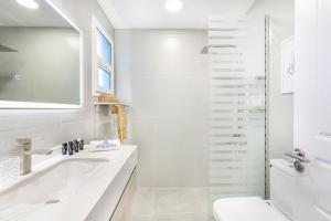 Luxurious Home in Silicon with Stylish Interior في دبي: حمام أبيض مع حوض ومرحاض