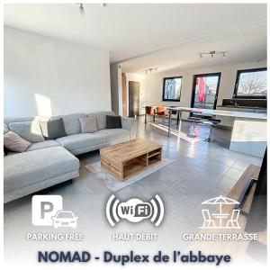 a living room with a couch and a table at NOMAD APARTMENTS - Duplex de l'abbaye 