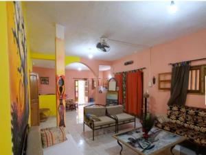 a living room with pink and yellow walls at Villa keur Fatou in Sali Nianiaral