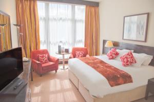 a hotel room with a bed and two chairs and a television at Kinsale Hotel & Spa in Kinsale