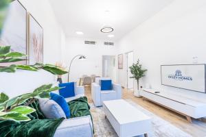 a living room with blue and white furniture and plants at Luxurious Home in Silicon with Stylish Interior in Dubai