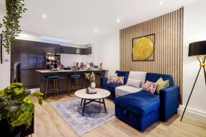 a living room with a blue couch and a table at Charming 2 bed House in London - Roof Top Terrace in London