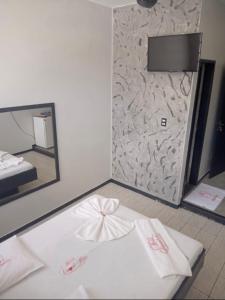 a room with a white bed with a mirror and a bedvertisement at Hotel Canal Hum Pistão in Brasilia
