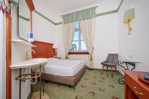 a bedroom with a bed and a sink and a window at Tafernwirtschaft Hotel Schönbrunn in Landshut