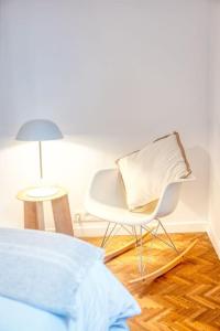 een witte stoel en een lamp in een slaapkamer bij 2-BR Haven in Antwerp in Antwerpen