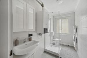 a white bathroom with a sink and a shower at Modernes 4 Zimmer Apartment mit brandneuer Einrichtung in Wuppertal