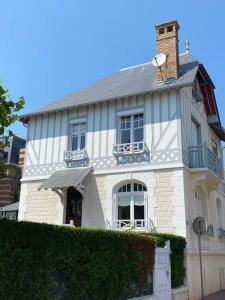 a white house with a chimney on top of it at Villa Soleil Levant in Deauville