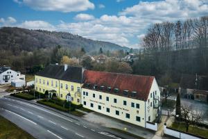 un grand bâtiment blanc avec un toit rouge à côté d'une route dans l'établissement Tafernwirtschaft Hotel Schönbrunn, à Landshut