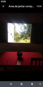 a room with a red bed with a window at Chácara lua e sol in Pouso Alegre