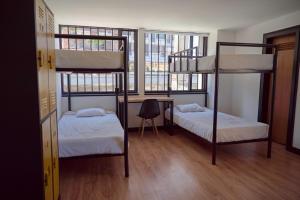 a room with two bunk beds and a desk at Best view Bogota Central Hostel in Bogotá