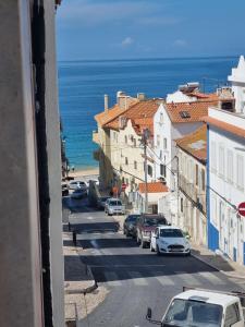 a view of a street with cars parked on the street at Boho Chic Beach Duplex in Sesimbra