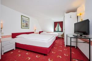 a hotel room with two beds and a flat screen tv at Tafernwirtschaft Hotel Schönbrunn in Landshut
