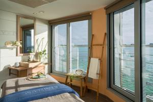 a bedroom with a view of the ocean at Résidences Valdys Thalasso & Spa de Rockroum in Roscoff