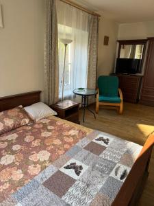 Un dormitorio con una cama y una silla y una ventana. en Tilto 6, en Vilna