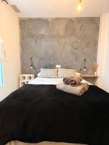 a bedroom with a large bed with a gray wall at Apartamento San Juan 1 in Murcia