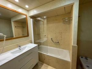 ein Badezimmer mit Waschbecken, Badewanne und Spiegel in der Unterkunft SEGUNDA PLANTA EN PRIMERA LINEA EN URB. JARDINES DE ISLA CANELA in Punta del moral + 7 Fotos