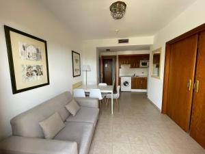 ein Wohnzimmer mit Sofa und Tisch in der Unterkunft SEGUNDA PLANTA EN PRIMERA LINEA EN URB. JARDINES DE ISLA CANELA in Punta del moral