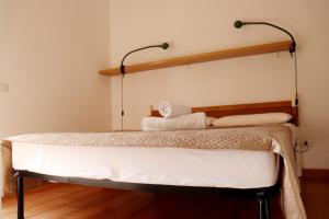 two beds in a room with two lamps on the wall at Moon Valley la pelosa in Stintino