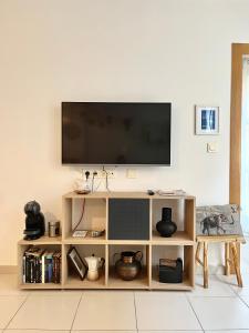sala de estar con TV en una pared blanca en Apartamento San Juan 1 en Murcia