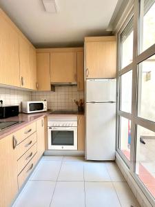 a kitchen with a white refrigerator and a window at Apartamento San Juan 1 in Murcia
