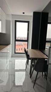 勒德烏齊的住宿－Panoramic Ultracentral Apartment Rădăuți ACR，一间带桌椅和窗户的用餐室