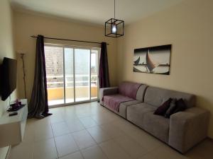 a living room with a couch and a window at Sunset Apartment in Praia