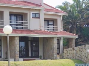 a house with a stone wall in front of it at Seaside, Marina Beach in Marina Beach