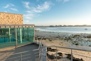 a house on the beach with a view of the water at Résidences Valdys Thalasso & Spa de Rockroum in Roscoff