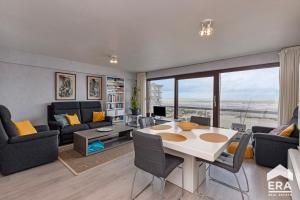 una sala de estar con una mesa y sillas en Yquem 0601, en Oostduinkerke