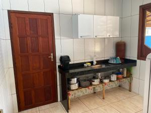 - une cuisine avec un évier et un comptoir avec des casseroles dans l'établissement Pousada clair, à Ibitirama