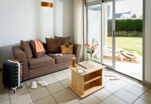 a living room with a couch and a table at Résidences Valdys Thalasso & Spa de Rockroum in Roscoff