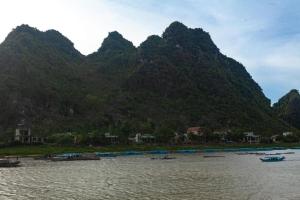een groep boten in het water voor een berg bij Riverview Home in Quang Binh