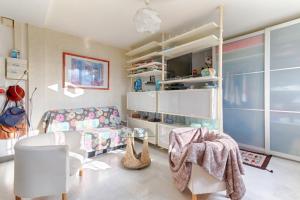 een woonkamer met een bank en een stoel bij Résidor - Cozy studio 10 minutes from Paris in Les Lilas