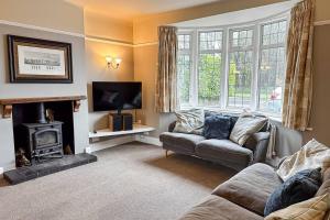 sala de estar con sofá y chimenea en Stunning house, sleeps 10, garden and pool table - West Parley Manor, en West Parley