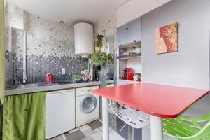 een keuken met een rode tafel en een wasmachine bij Résidor - Cozy studio 10 minutes from Paris in Les Lilas
