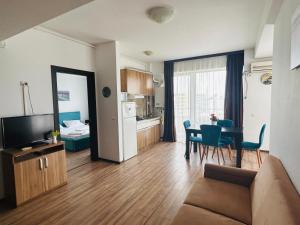 a living room with a couch and a dining room table at Maria Summer Apartaments in Mamaia