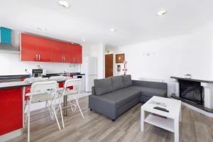 Agualva Happy Apartment في Paiõis: مطبخ وغرفة معيشة مع أريكة وطاولة