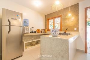 een keuken met een roestvrijstalen koelkast en een aanrecht bij Casa c/ Piscina em Arraial D'Ajuda - CDO009 in Porto Seguro
