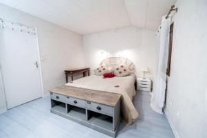 a white bedroom with a bed and a table at Belle maison et jardin à Pessac 10 pers in Pessac