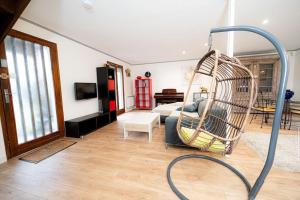 a living room with a swing in the middle at Belle maison et jardin à Pessac 10 pers in Pessac