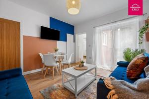 ein Wohnzimmer mit einem blauen Sofa und einem Tisch in der Unterkunft Accessible ground floor wet room and bedroom in a modern 4 Bedroom House-B28 Hall Green in Birmingham