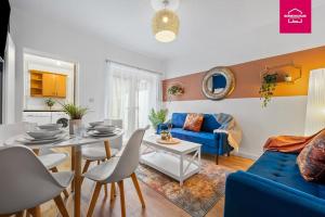 ein Wohnzimmer mit einem Tisch und einem blauen Sofa in der Unterkunft Accessible ground floor wet room and bedroom in a modern 4 Bedroom House-B28 Hall Green in Birmingham