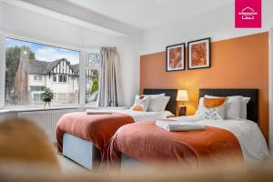 ein Schlafzimmer mit zwei Betten und einem großen Fenster in der Unterkunft Accessible ground floor wet room and bedroom in a modern 4 Bedroom House-B28 Hall Green in Birmingham