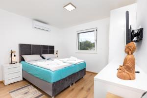 a bedroom with a king sized bed and a statue at Apartma Skubic Murvica in Vantačići +17 photos