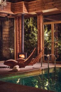 a swimming pool with a fireplace next to a house at NoName Resort in Łapsze Niżne