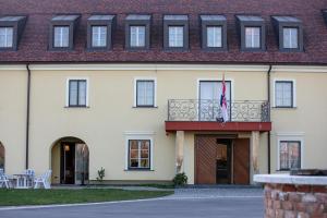 um edifício com uma varanda e uma bandeira em Hotel Dvorac Jurjevec em Lekenik