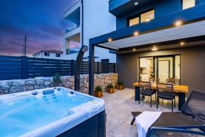 a hot tub in the backyard of a house at Apartma Skubic Murvica in Vantačići
